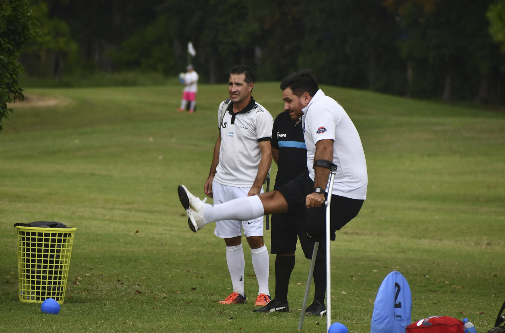 Jugador pateando una pelota de footgolf junto a otros competidores
